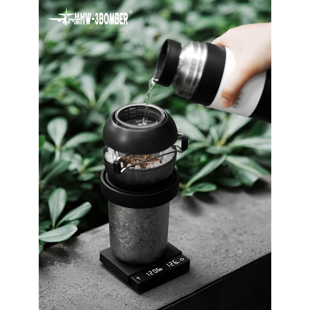 MHW-3Bomber Cube Micro coffee scale under a V60 brewer on a black countertop